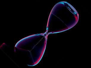 Hourglass,Illuminated,In,Red,And,Blue,On,A,Black,Background